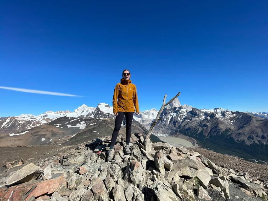 Female in orange jacket at the summit of Loma Del Pilegue Tumbado in Patagonia on 2 week trip