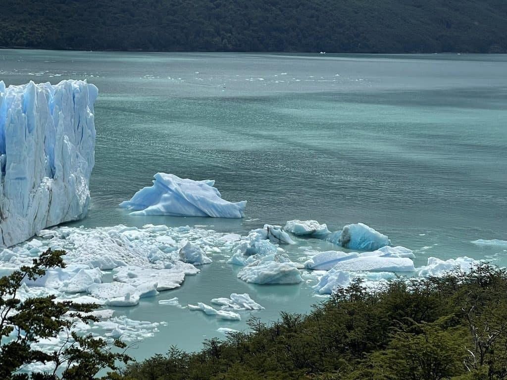 Pieces of glacier broken off and floating in water of a large glacier ice wall at Perito Moreno in El Calafate, Patagonia