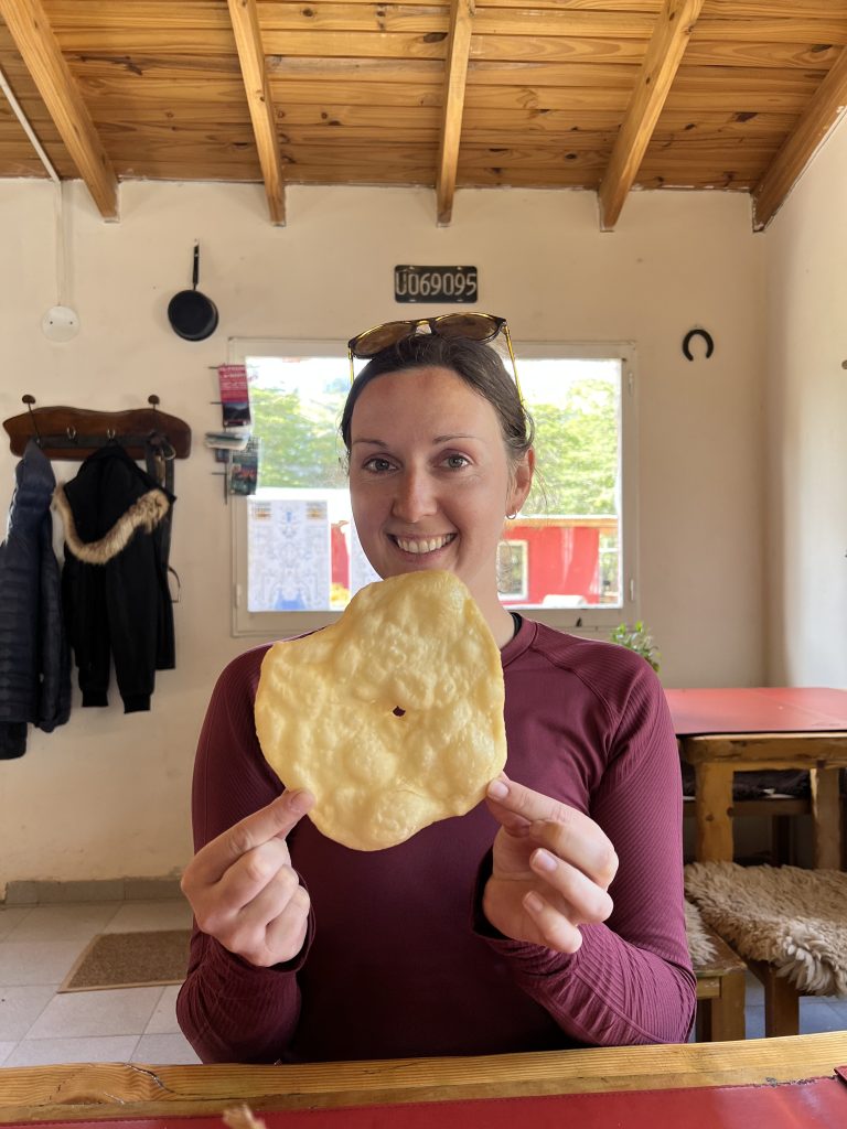 image of girl in red shirt holding a torta frita in el chalten